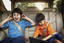 two kids in backseat of car