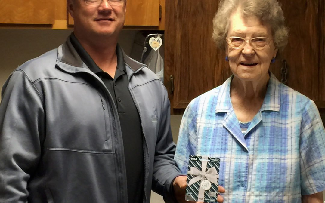District Manager, Ian Taylor presents Betty Sergun of Arnold, NE with her $100 Visa gift card.