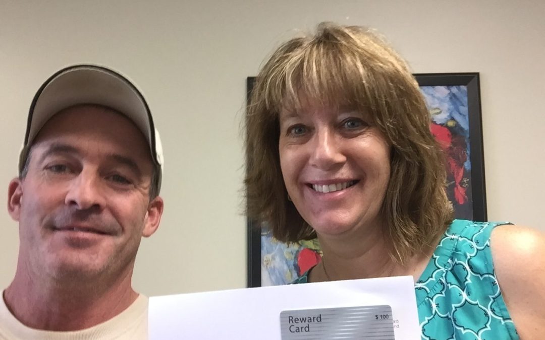 Lorna Eliason receives her gift card from technician  Jason Collins.