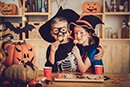 two kids in costume with halloween snacks