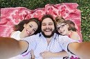 Summer scene of Happy young family taking selfies