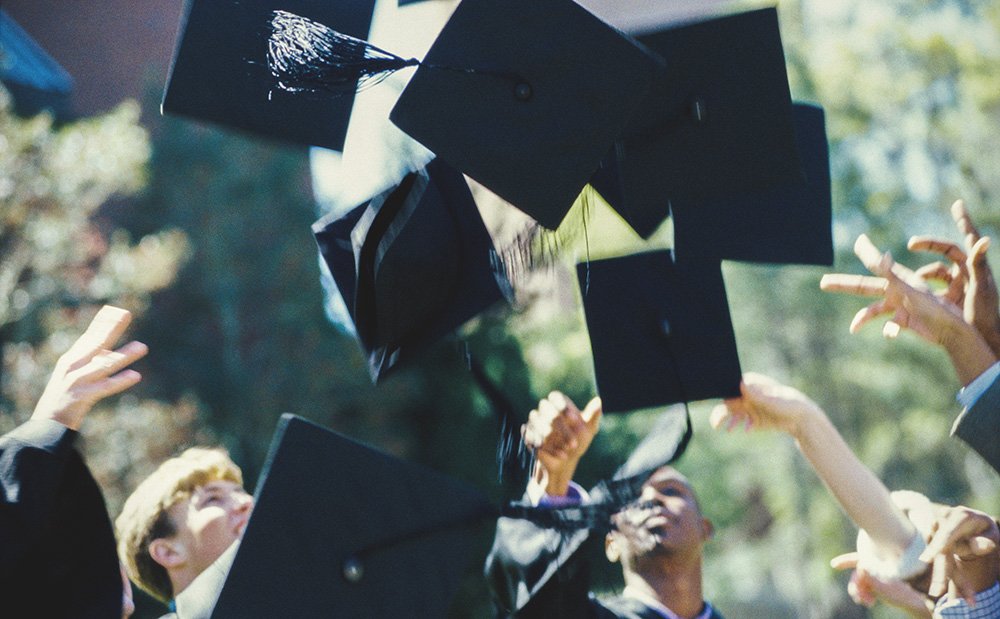 Students throwing their graduation hats in the air during a graduation ceremony