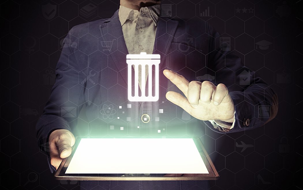 Man with tablet in his hands presses trash can icon