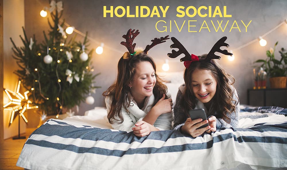 2 teen girls laying on a bed in reindeer antlers